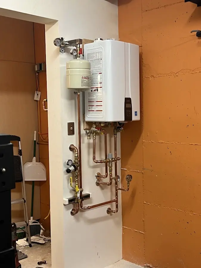 Plumbing technician inspecting water heater connections in Mount Pleasant